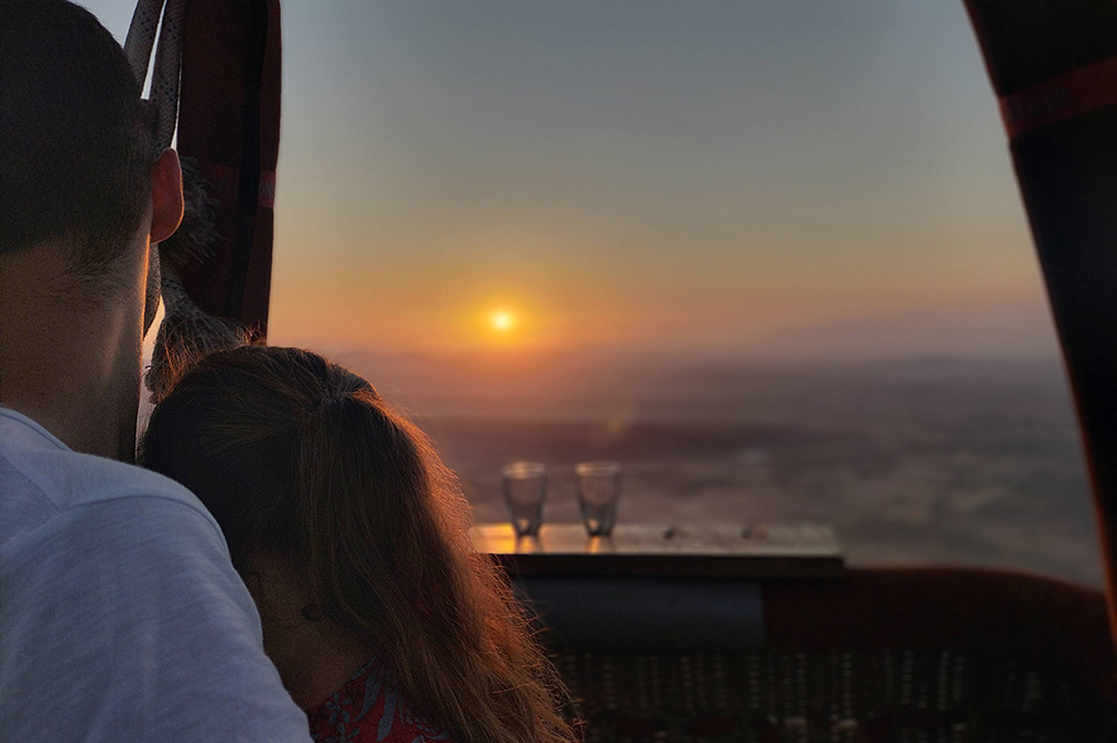 Romantic couple enjoing a sunset from a balloon basket